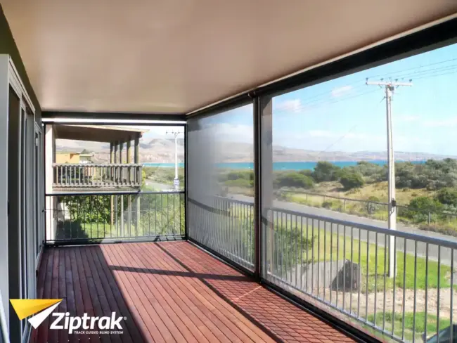 Coastal balcony with Ziptrak® outdoor blinds providing wind shade protection and ocean views