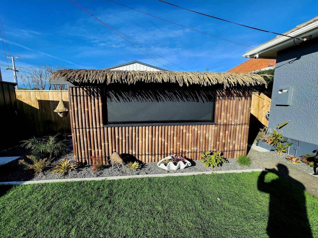 An outdoor spa enclosure, island style, with a black ziptrak screen inset