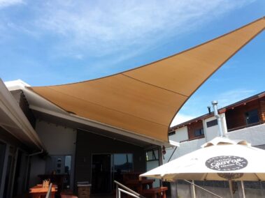 Outside-in view of Stoked Café in Whitianga using E32 Shade Cloth, installed by Outdoors Covered