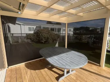 Covered patio with outdoor living blinds in off-white framing, featuring mesh outdoor blinds in Visiontex® Plus 94 Carbon Black with Ziptrak® off white blinds, enhancing outdoor screens NZ comfort by Rainbow Shade NZ