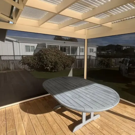 Covered patio with outdoor living blinds in off-white framing, featuring mesh outdoor blinds in Visiontex® Plus 94 Carbon Black with Ziptrak® off white blinds, enhancing outdoor screens NZ comfort by Rainbow Shade NZ