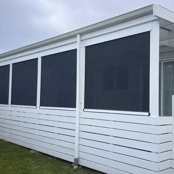 Stylish white exterior with outdoor living blinds installed along deck, featuring mesh outdoor blinds in Visiontex® Plus 94 carbon black with white Ziptrak® blinds, a modern outdoor blinds solution from Rainbow Shade NZ.