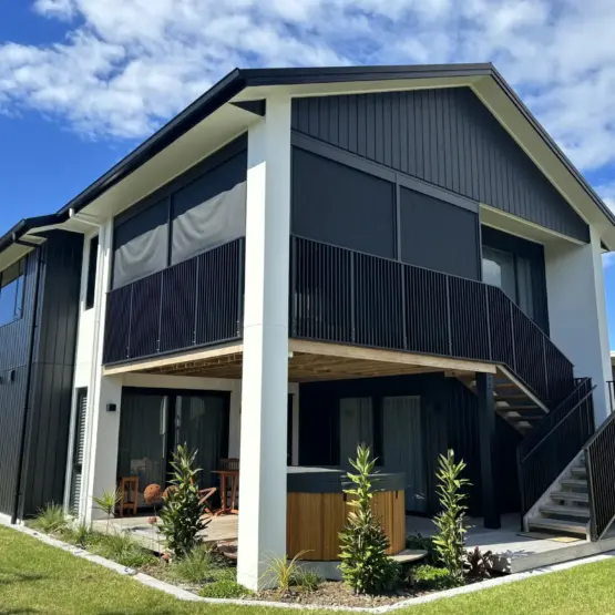 Corner perspective of elevated deck with outdoor living blinds in use, showing mesh outdoor blinds in Visiontex® Plus 94 with Ziptrak® blinds, a durable outdoor blinds NZ solution from Covered & Rainbow Shade NZ
