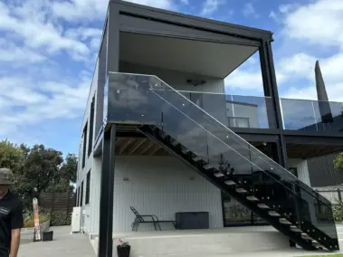 Upper-level deck enclosed with outdoor living blinds, using mesh outdoor blinds in Visiontex®® Plus 94 Carbon Black and Ziptrak®® blinds for weather protection, a premium outdoor screen installation in by Covered & Rainbow Shade NZ