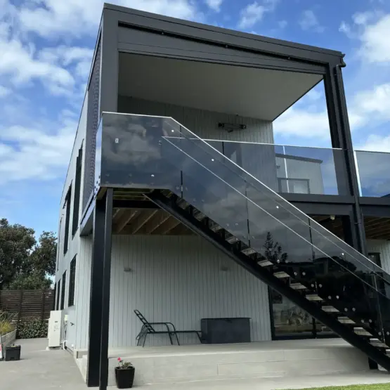 Upper-level deck enclosed with outdoor living blinds, using mesh outdoor blinds in Visiontex®® Plus 94 Carbon Black and Ziptrak®® blinds for weather protection, a premium outdoor screen installation in by Covered & Rainbow Shade NZ